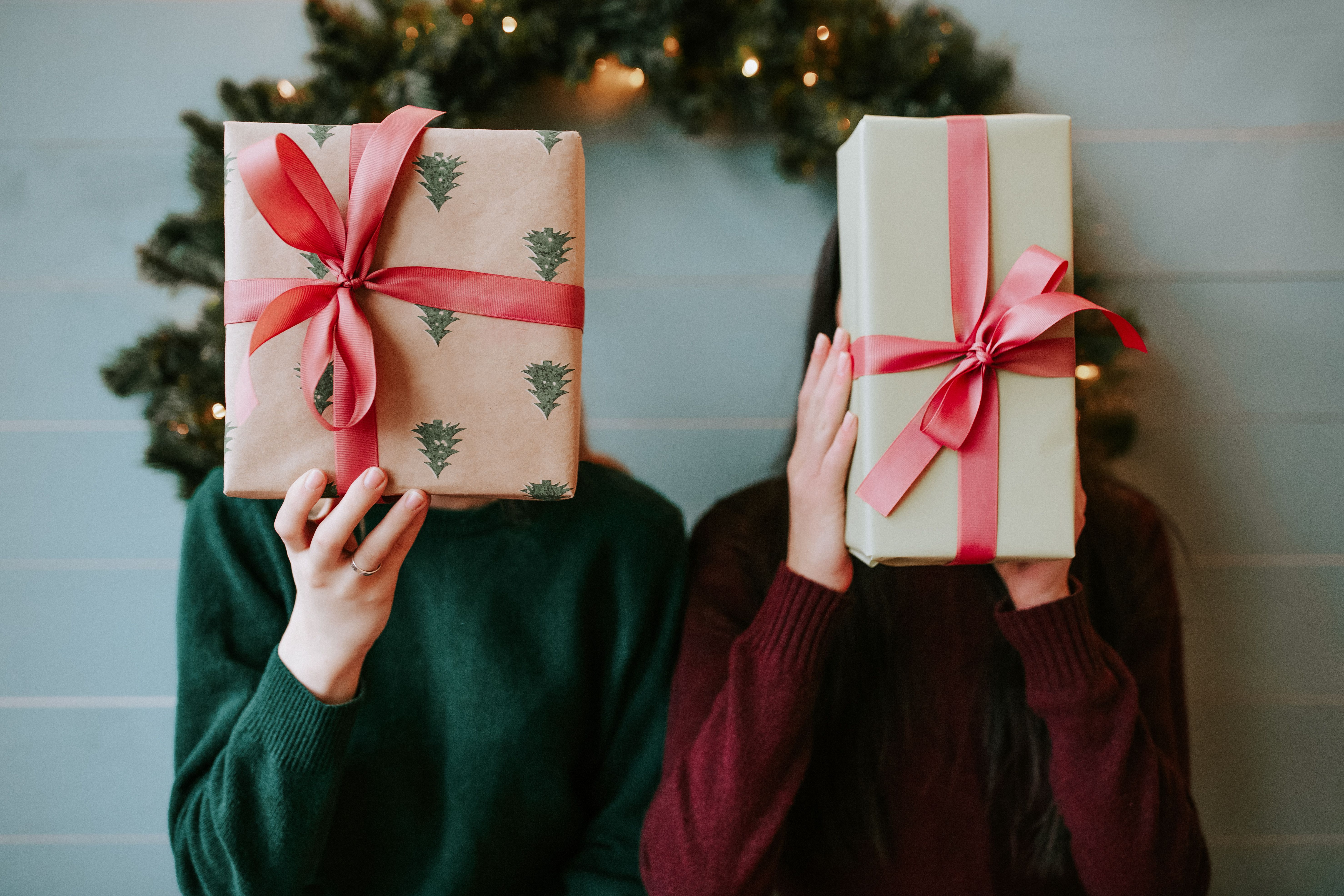 Two guests holding beautifully wrapped gifts